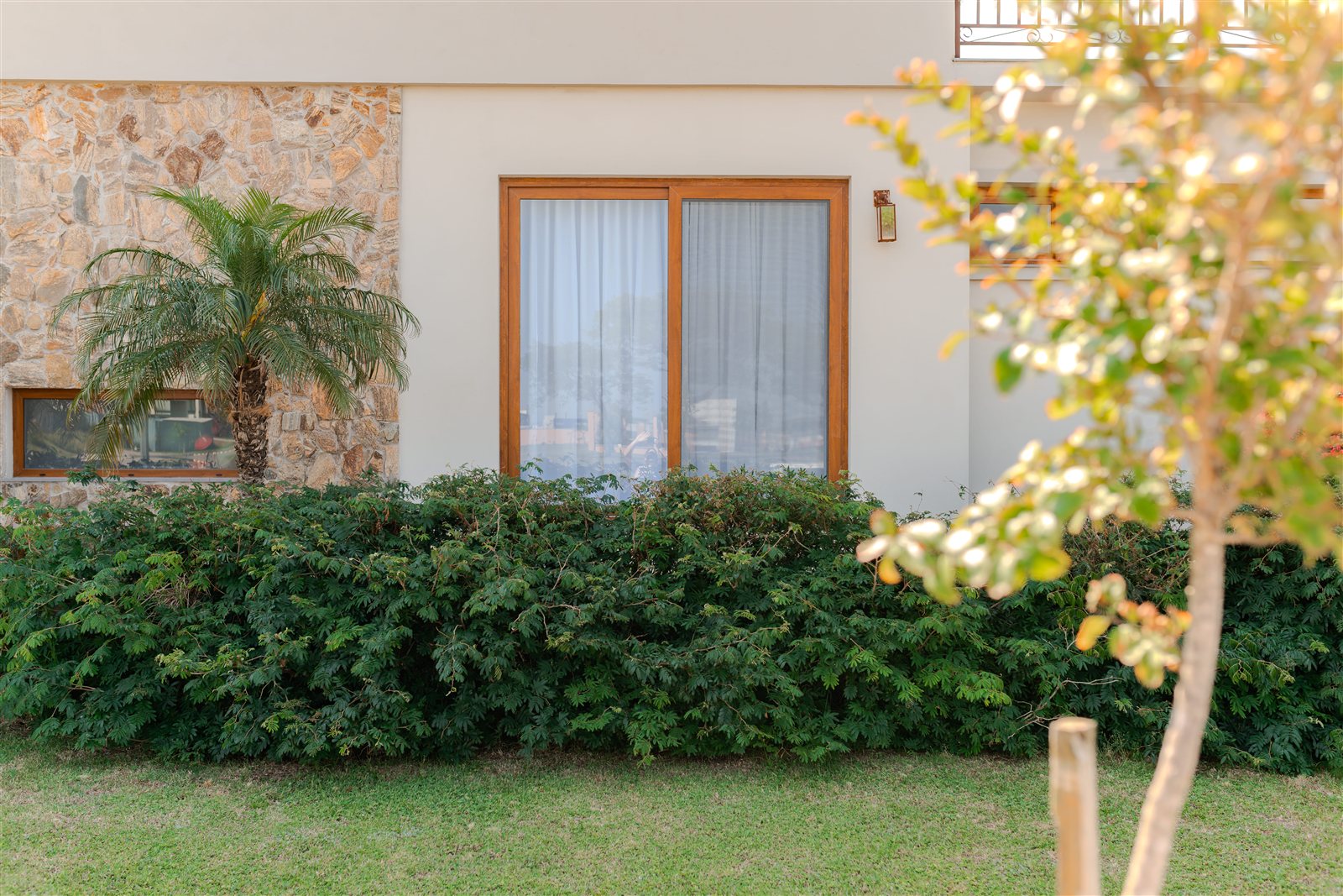 Esquadria com acabamento amadeirado voltada para o jardim